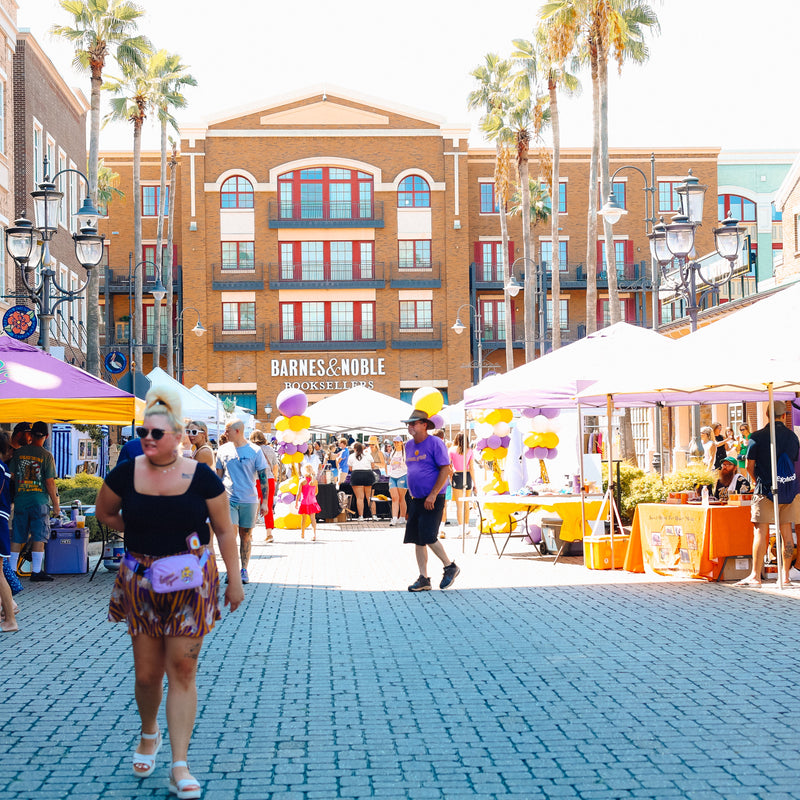Outdoor market Ultimate Tailgate with people walking and shopping in a town square at Perkins Rowe