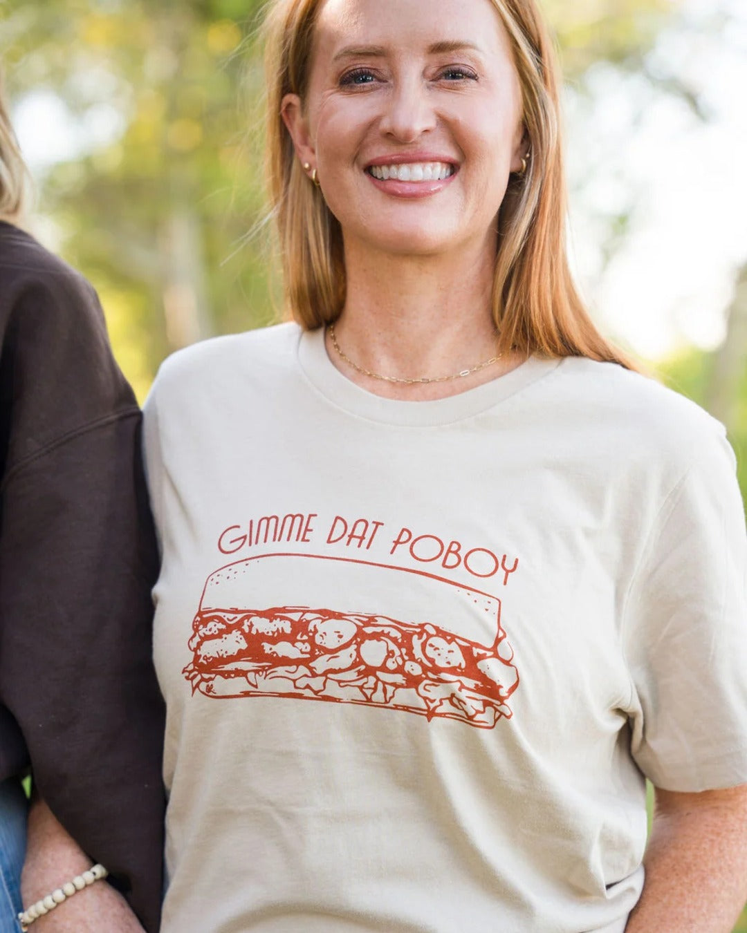 Smiling model in the Gimme Dat Poboy T-Shirt, a Louisiana food tee by Sweet Baton Rouge